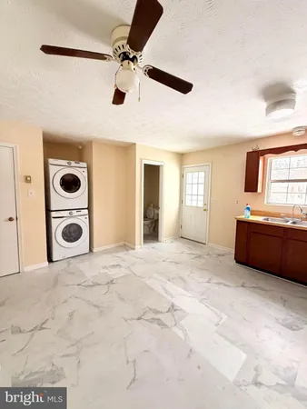 a view of a livingroom with a kitchen and a ceiling fan