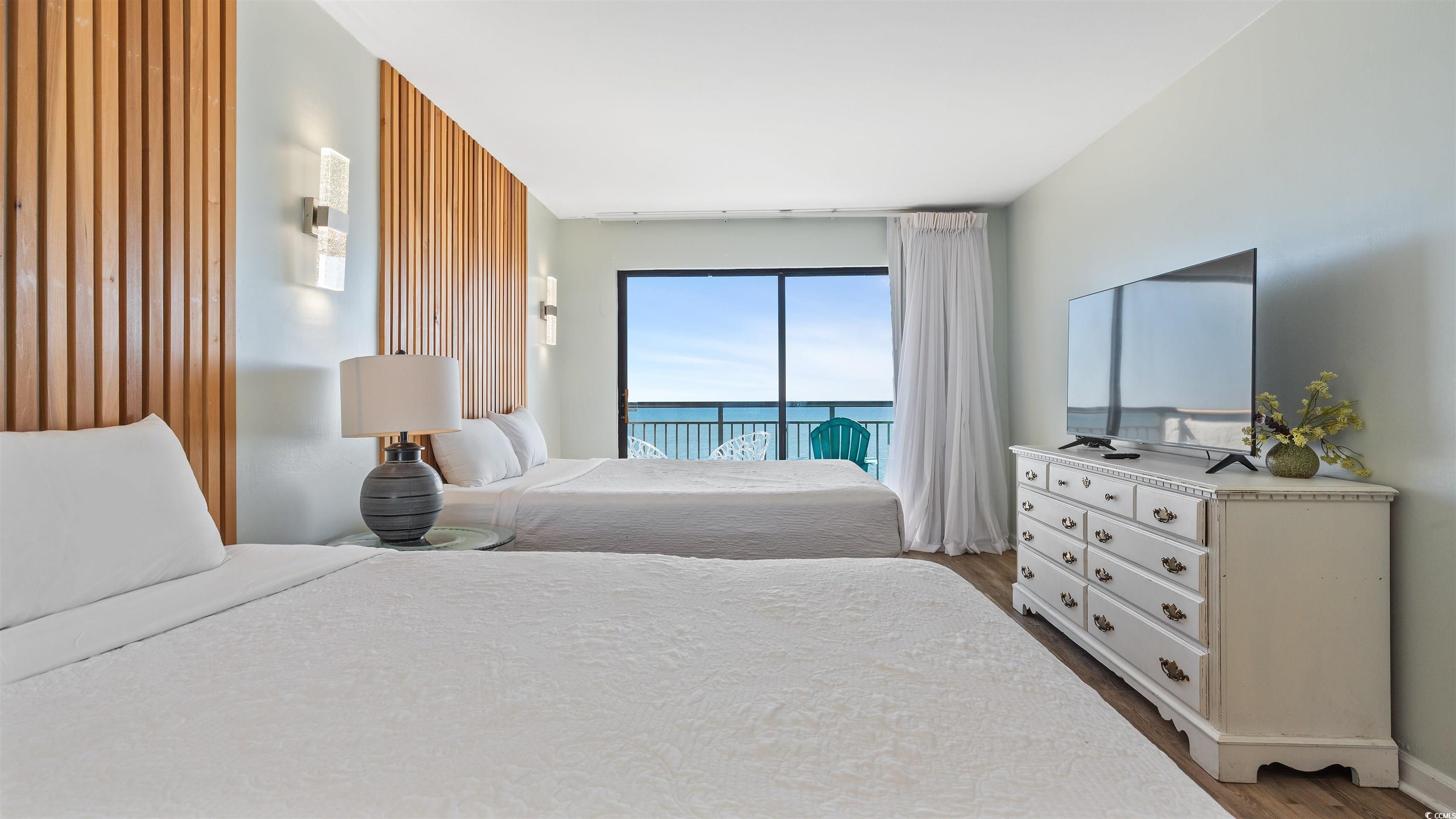 2001 South Ocean Boulevard, Unit 603 Myrtle Beach, SC 29577 - Photo 12 of 33 Bedroom with access to exterior and dark wood-style flooring