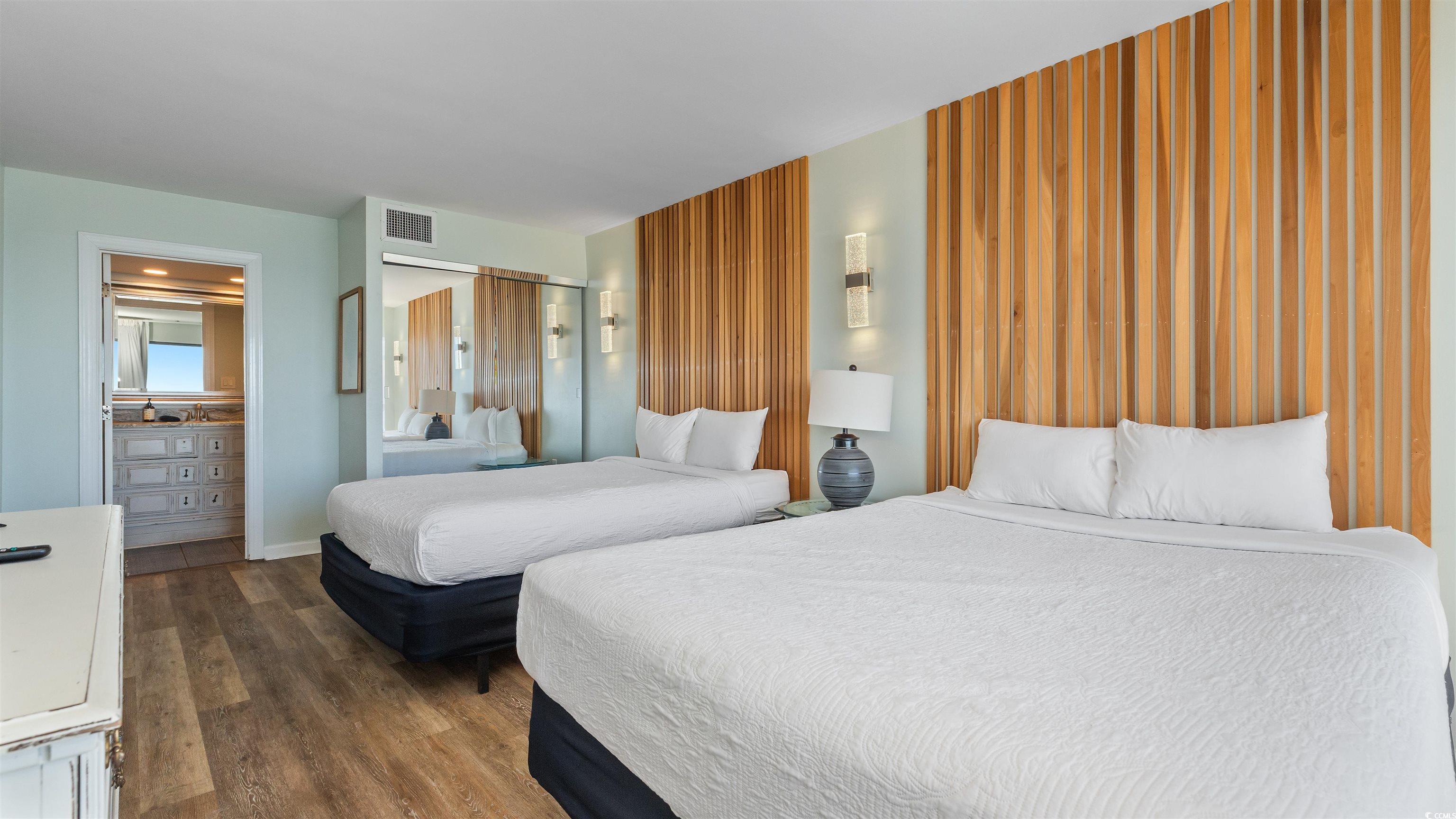 2001 South Ocean Boulevard, Unit 603 Myrtle Beach, SC 29577 - Photo 10 of 33 Bedroom featuring dark wood-type flooring and ensuite bath