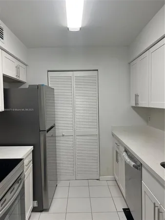 a kitchen with a refrigerator and a stove top oven