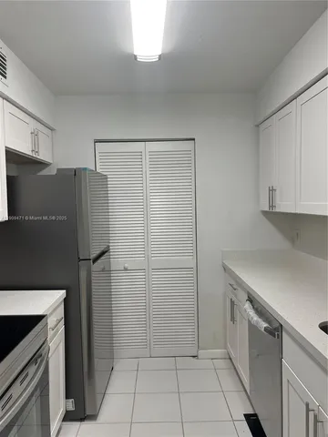 a kitchen with a refrigerator and a stove top oven