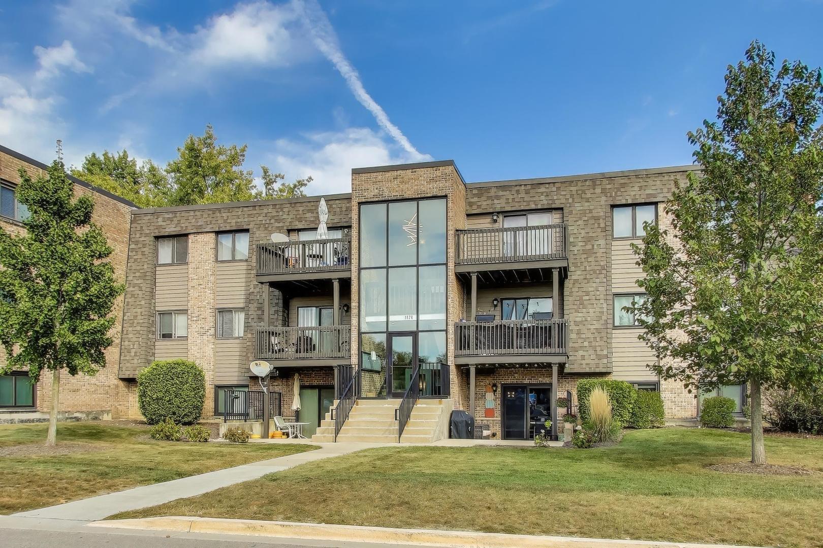 1424 Stonebridge Circle, Unit L4 Wheaton, IL 60189 - Photo 2 of 24 front view of a building with a yard