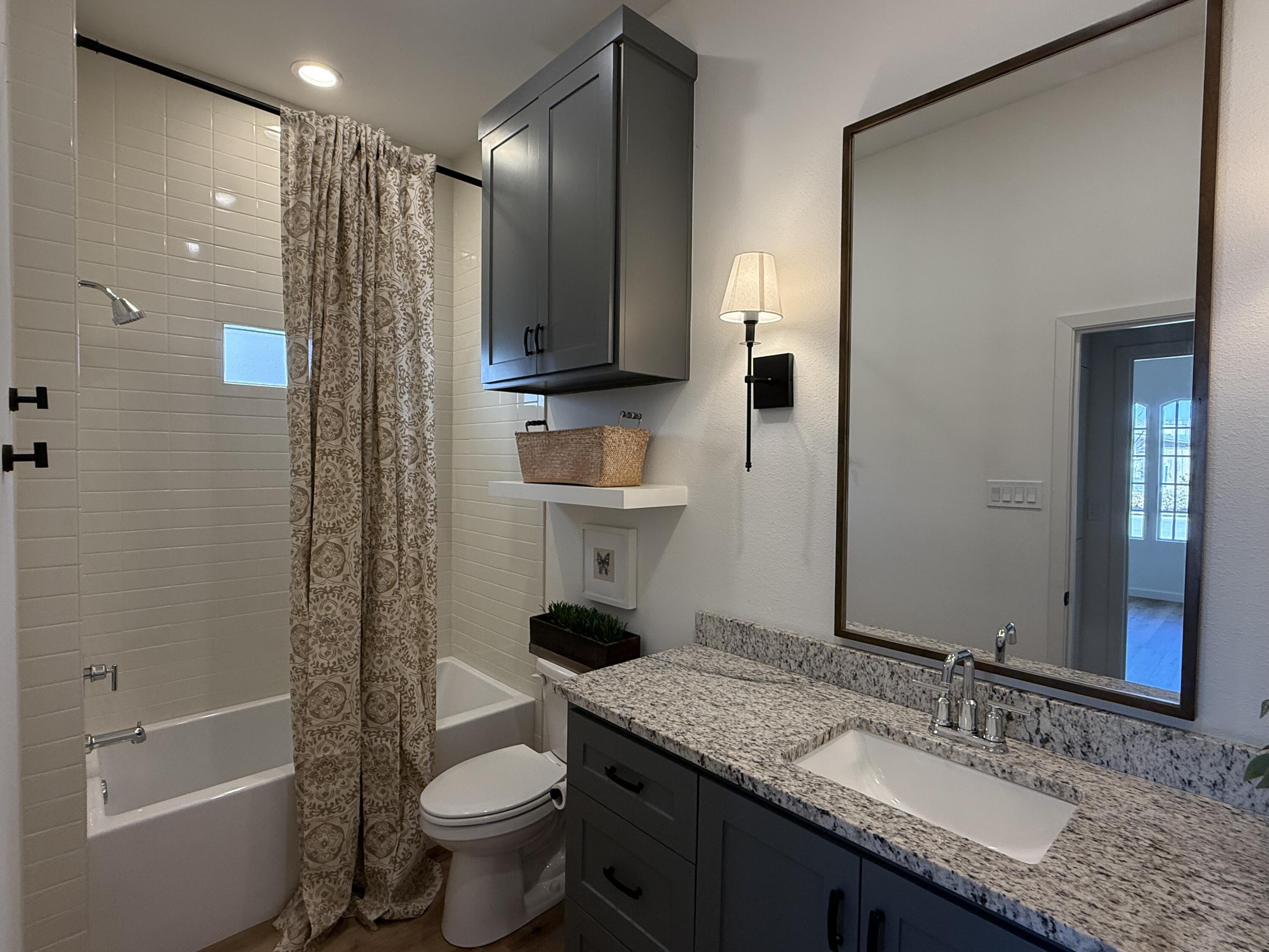 3605 128th Street Lubbock, TX 79423 - Photo 18 of 23 a bathroom with a granite countertop sink toilet and shower