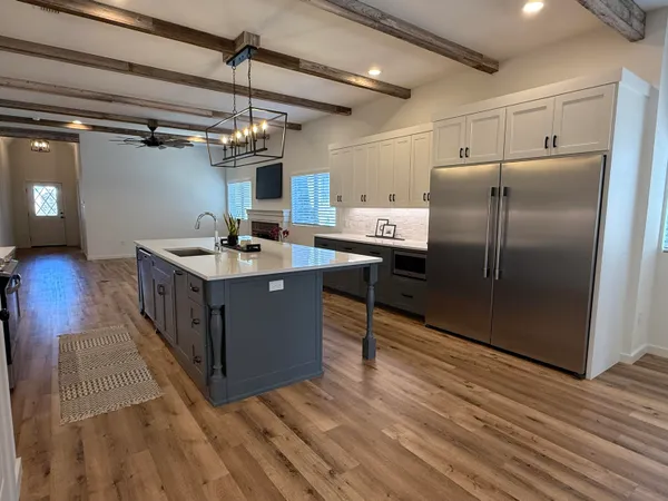 a kitchen with stainless steel appliances granite countertop a sink and a refrigerator