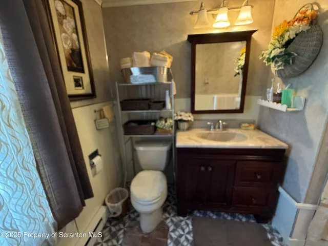 a bathroom with a toilet sink and mirror