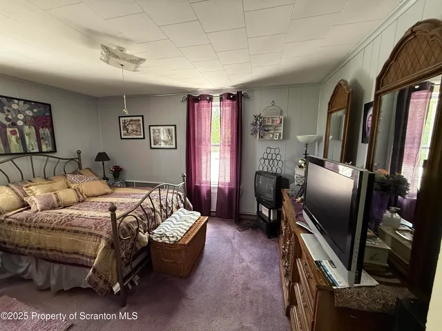 a bed room with a bed furniture and a flat screen tv