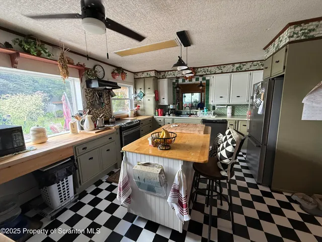 a kitchen with stainless steel appliances granite countertop a stove a sink a refrigerator and wooden floor