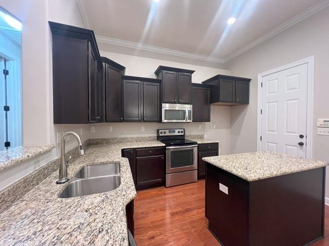 1977 Rochelle Lane Cordova, TN 38016 - Photo 10 of 26 a kitchen with kitchen island granite countertop a sink dishwasher stove and refrigerator with wooden floor