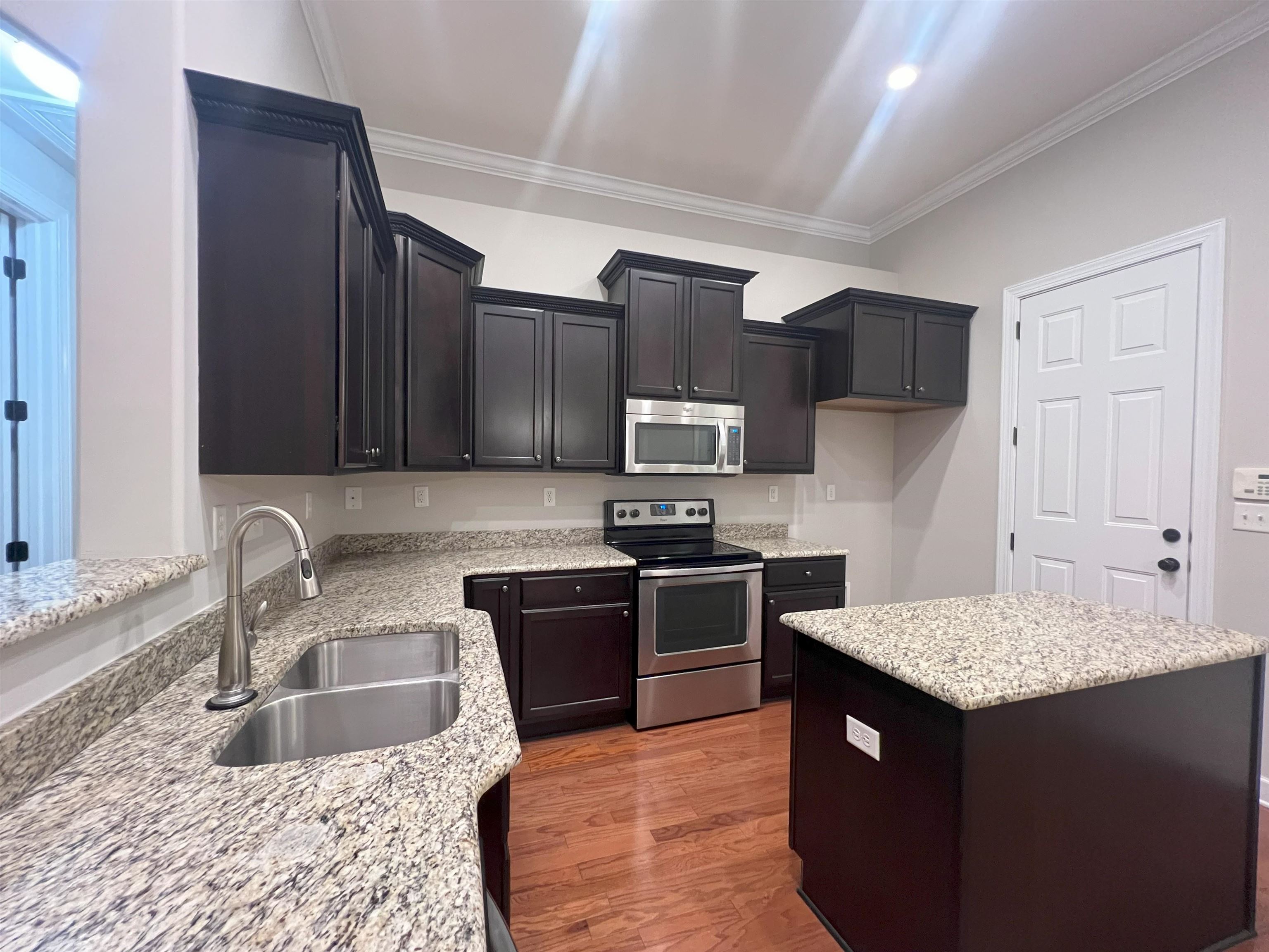 1977 Rochelle Lane Cordova, TN 38016 - Photo 12 of 26 a kitchen with kitchen island granite countertop a sink dishwasher stove and refrigerator with wooden floor