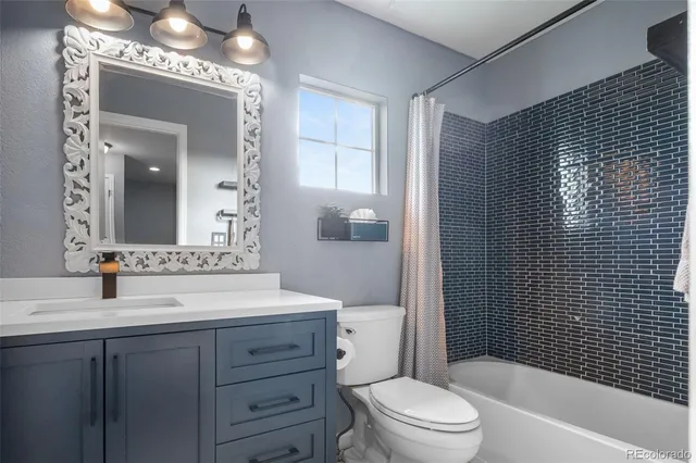 a bathroom with a sink a toilet a mirror and shower