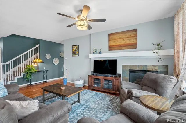 a living room with furniture a flat screen tv and a fireplace
