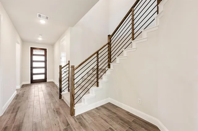 an entryway in a hall with a window and wooden floor