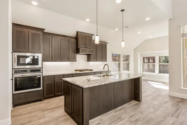 a kitchen with a sink stove and refrigerator