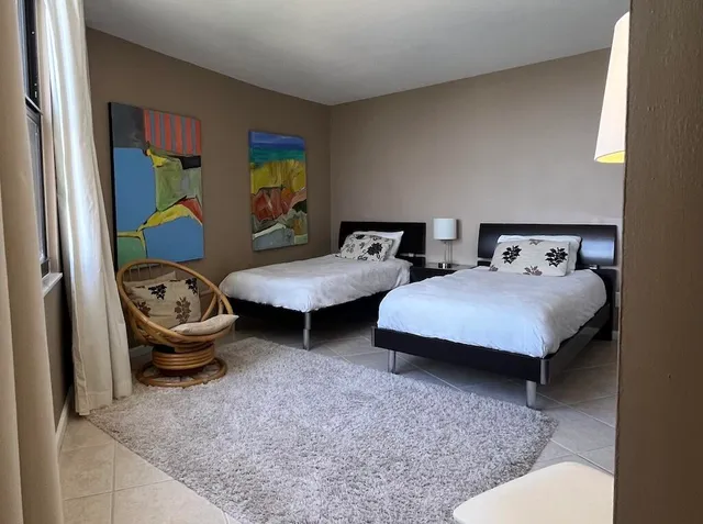 a bedroom with 2 bed and window