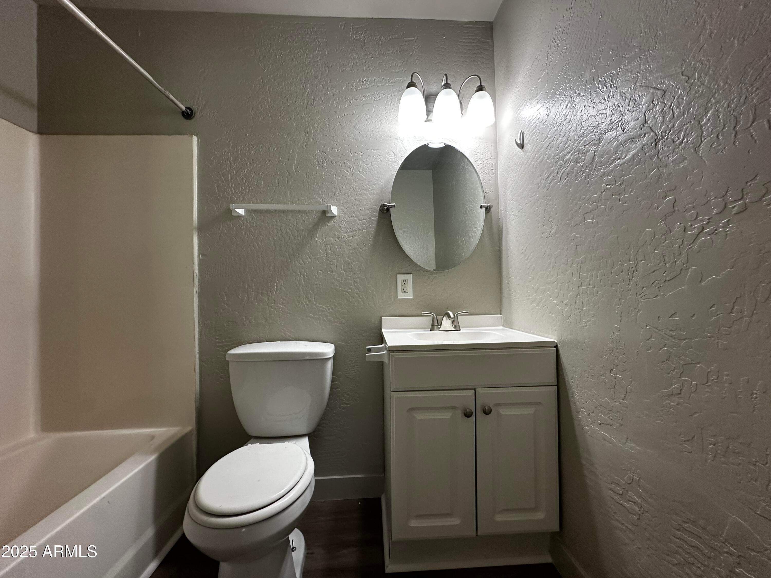 1421 East Fillmore Street, Unit 4 Phoenix, AZ 85006 - Photo 12 of 18 a bathroom with a toilet sink and mirror