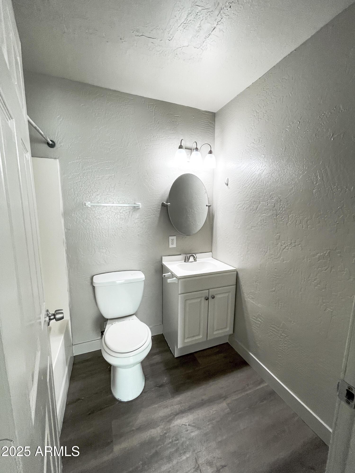 1421 East Fillmore Street, Unit 4 Phoenix, AZ 85006 - Photo 13 of 18 a bathroom with a toilet sink and mirror