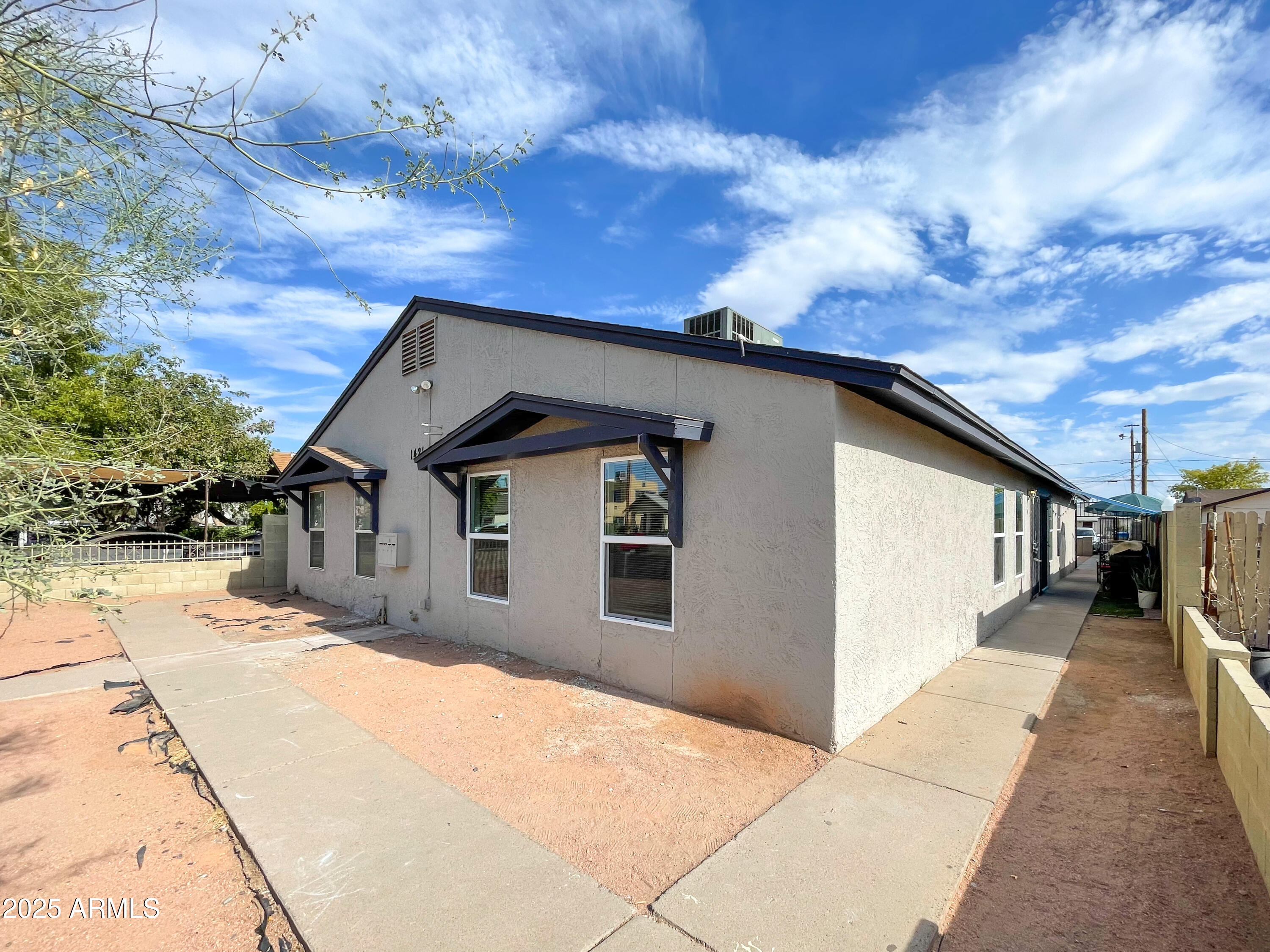 1421 East Fillmore Street, Unit 4 Phoenix, AZ 85006 - Photo 17 of 18 a yellow house with a outdoor space