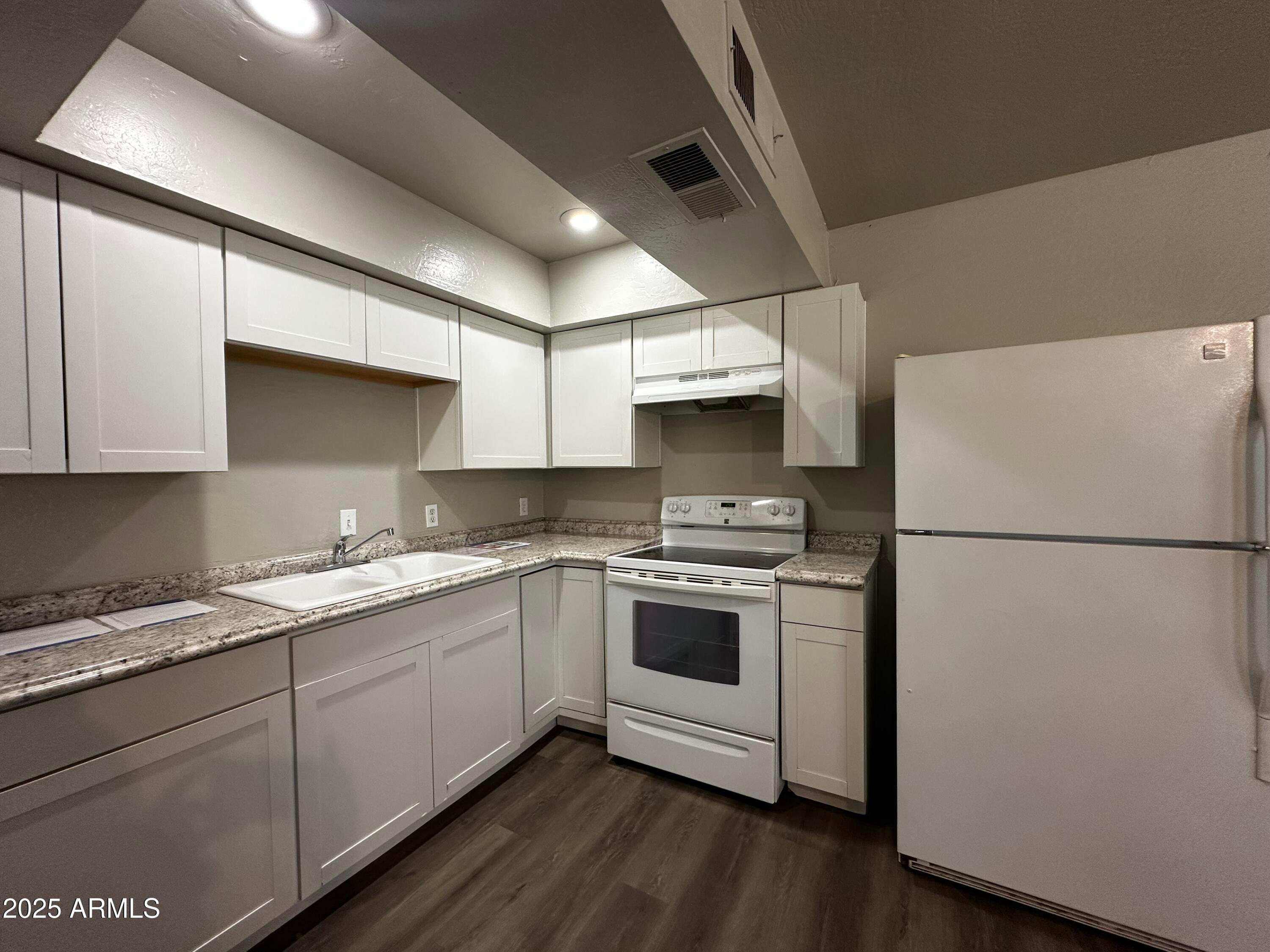 1421 East Fillmore Street, Unit 4 Phoenix, AZ 85006 - Photo 3 of 18 a kitchen with a white cabinets and white appliances
