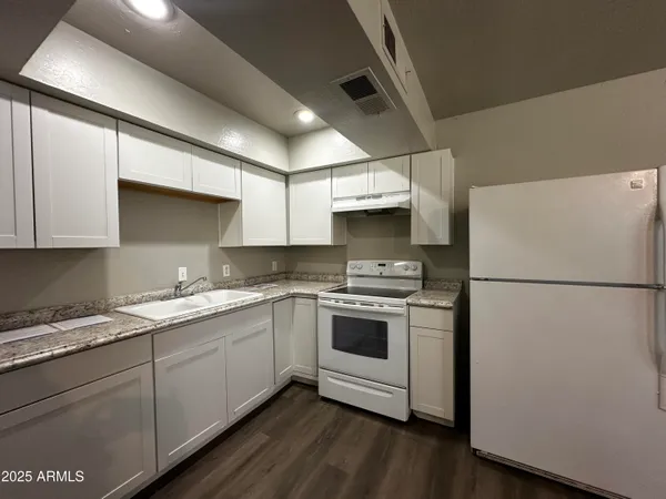 a kitchen with a white cabinets and white appliances