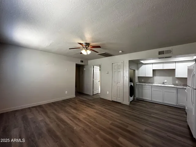 a view of a kitchen with a sink and dishwasher a stove top oven with wooden floor