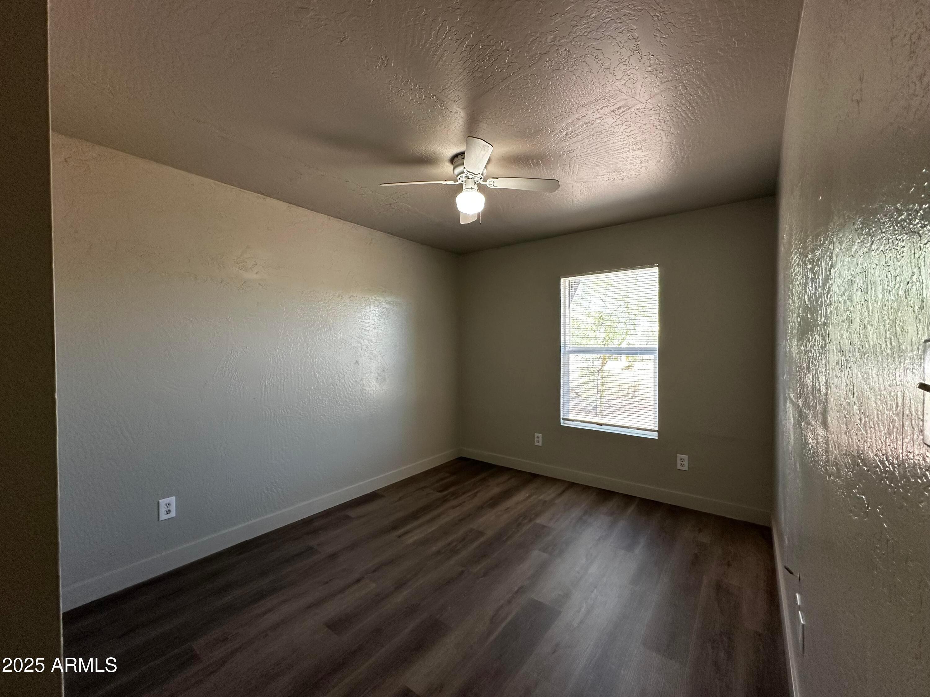 1421 East Fillmore Street, Unit 4 Phoenix, AZ 85006 - Photo 7 of 18 an empty room with wooden floor and windows