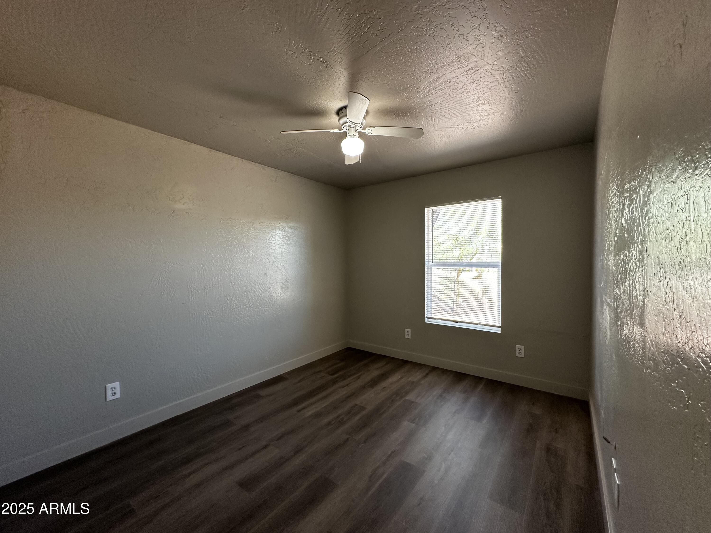 1421 East Fillmore Street, Unit 4 Phoenix, AZ 85006 - Photo 8 of 18 an empty room with wooden floor and windows