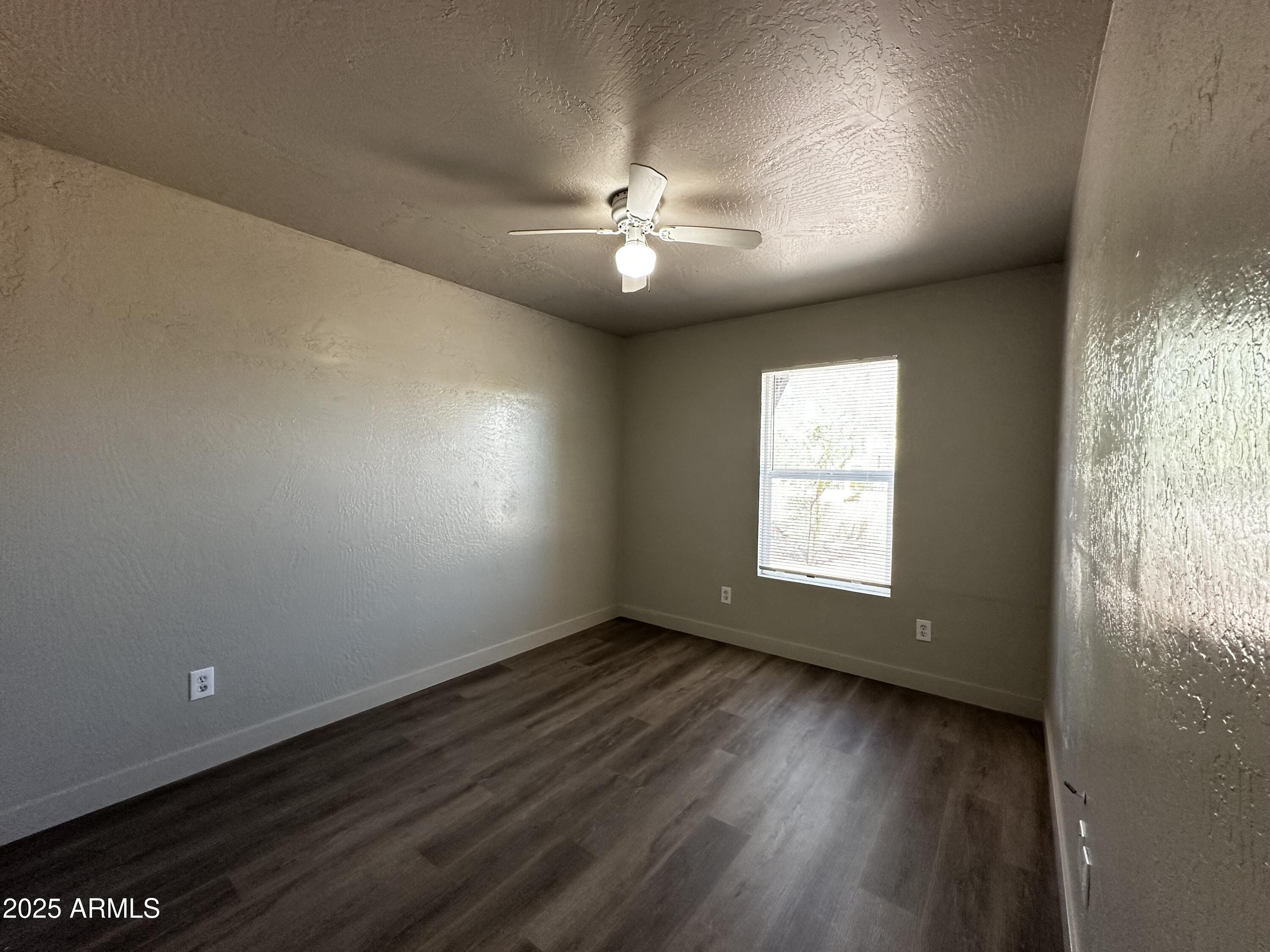 1421 East Fillmore Street, Unit 4 Phoenix, AZ 85006 - Photo 9 of 18 an empty room with wooden floor and windows