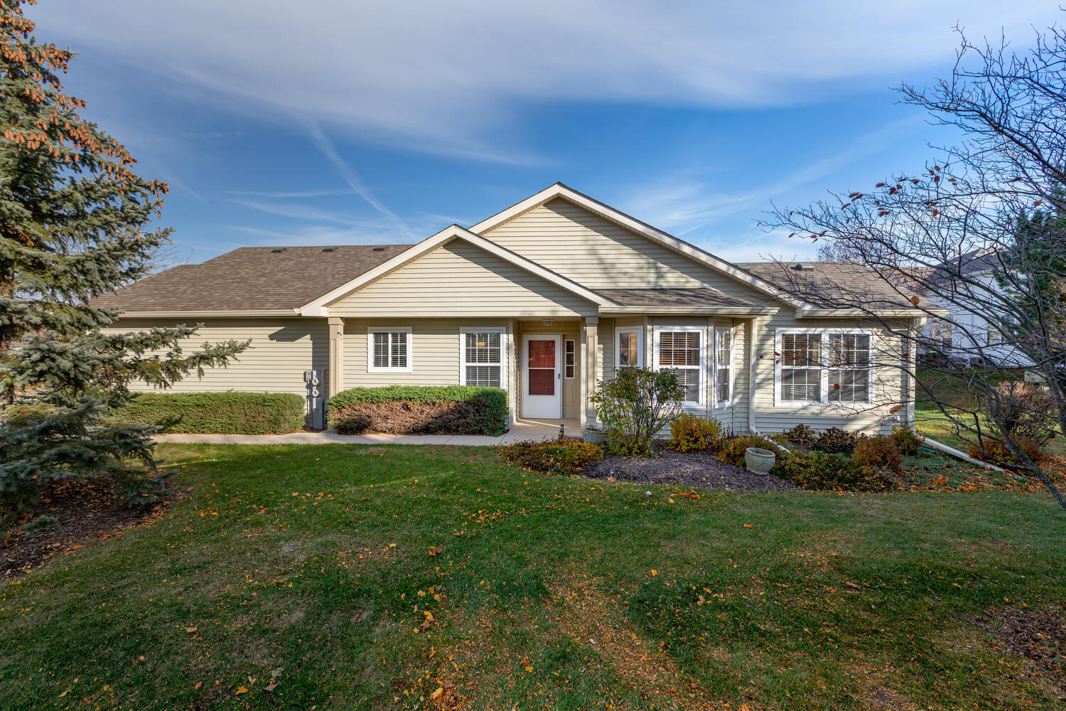 a front view of a house with a yard and trees