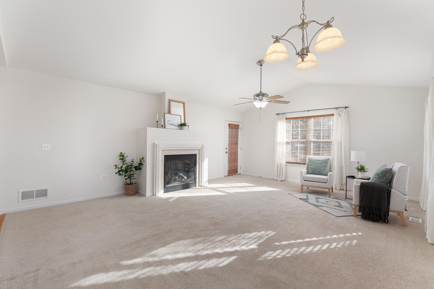 31 Rolling Oaks Road, Unit A Sugar Grove, IL 60554 - Photo 6 of 25 a view of a livingroom with a fireplace a chandelier and windows