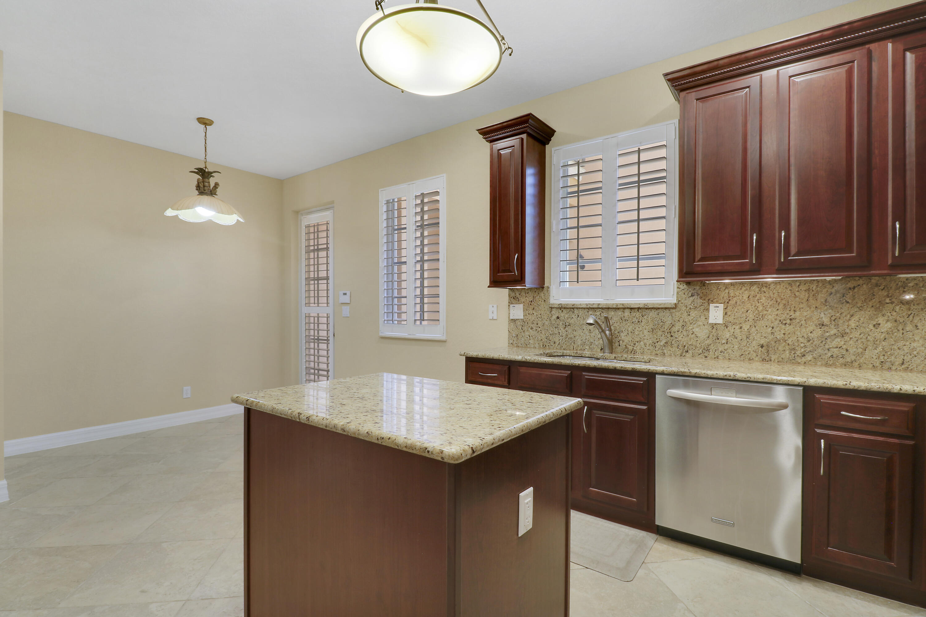 138 Tallow Trail Jupiter, FL 33458 - Photo 11 of 38 a kitchen with granite countertop a sink dishwasher and cabinets with wooden floor