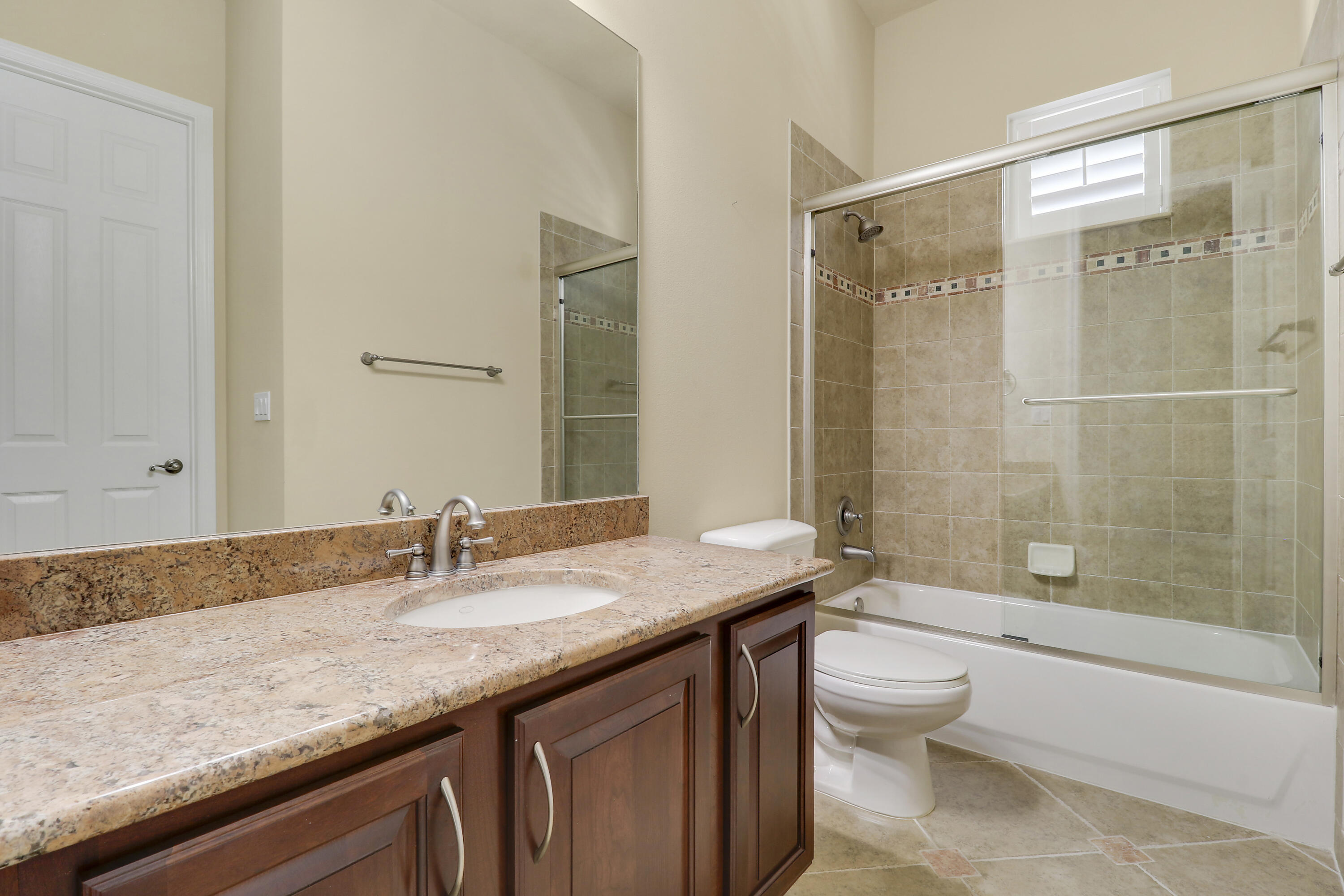 138 Tallow Trail Jupiter, FL 33458 - Photo 26 of 38 a bathroom with a granite countertop sink a toilet a mirror and shower