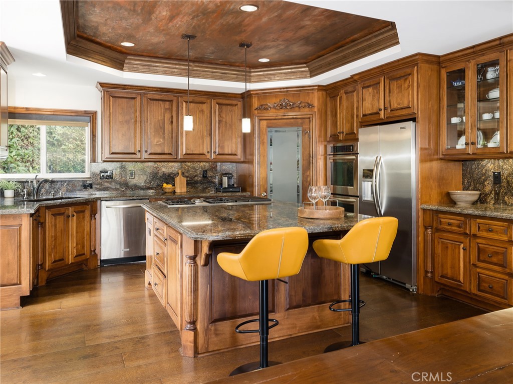8 Stallion Road Rancho Palos Verdes, CA 90275 - Photo 17 of 56 a kitchen with stainless steel appliances granite countertop a sink a stove and chairs with wooden floor