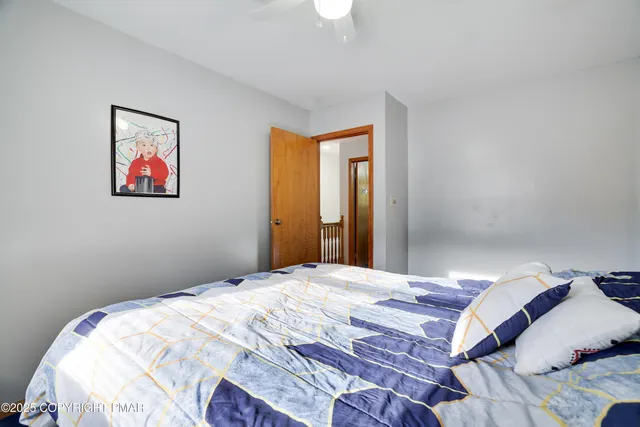 a bedroom with a bed and a painting on the wall