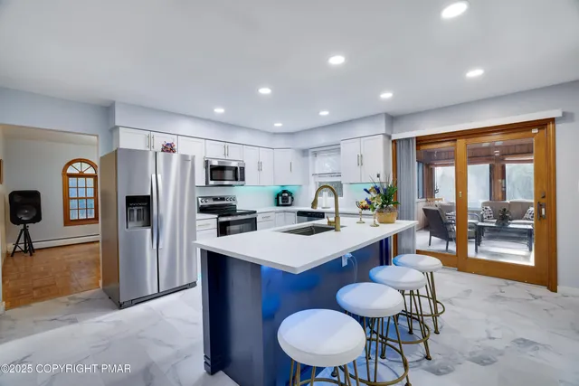 a open kitchen with stainless steel appliances a dining table and chairs