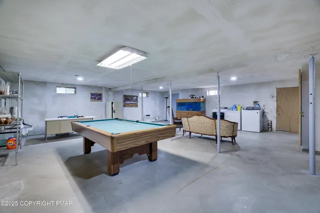 a living room with furniture a pool table and a fireplace
