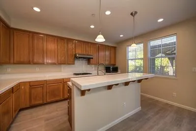 a kitchen with stainless steel appliances granite countertop a sink a stove and cabinets