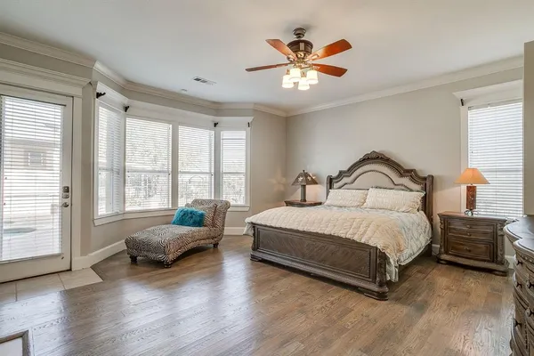 a spacious bedroom with a bed a couch and large window