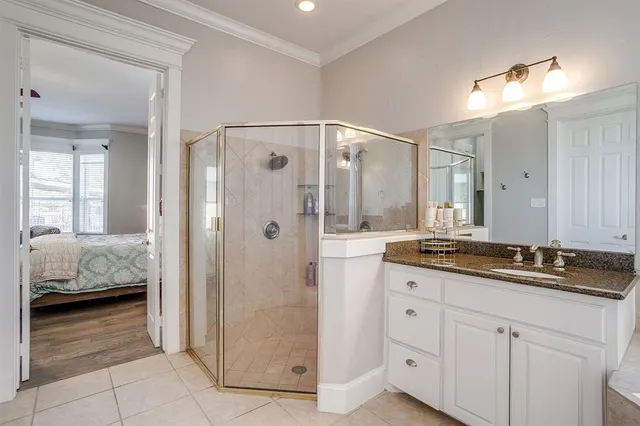 a en suite bathroom with a granite countertop sink mirror and shower