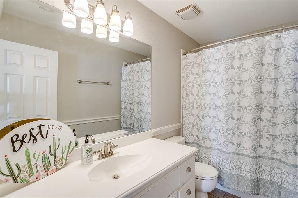 253 Bayne Road Haslet, TX 76052 - Photo 28 of 40 a bathroom with a toilet a sink and a mirror