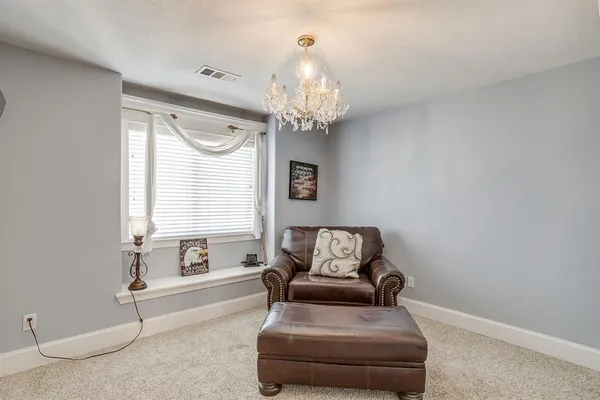 a living room with furniture and a chandelier