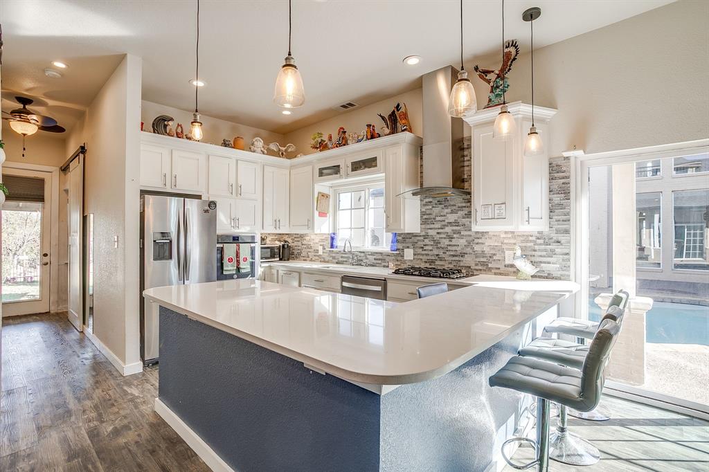 253 Bayne Road Haslet, TX 76052 - Photo 34 of 40 a large kitchen with kitchen island a large counter top space appliances and cabinets