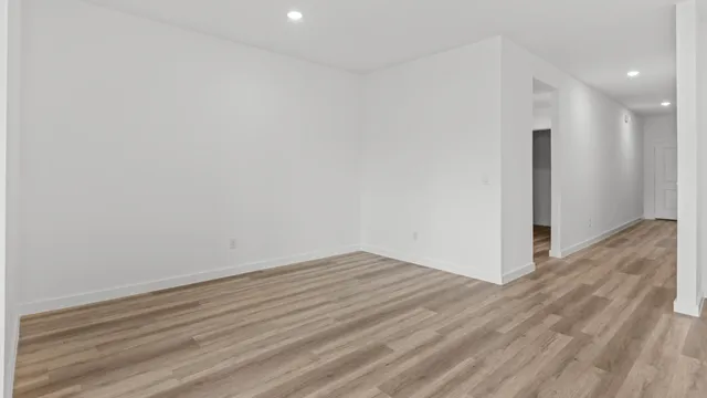 a view of an empty room with wooden floor and closet
