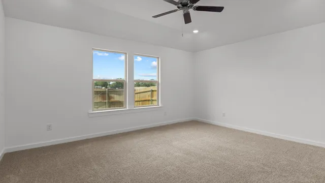 an empty room with a window and a fan