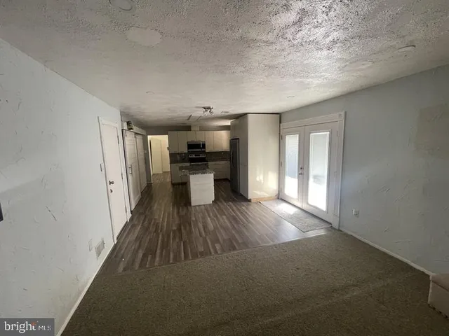 a view of a kitchen with wooden floor and a window