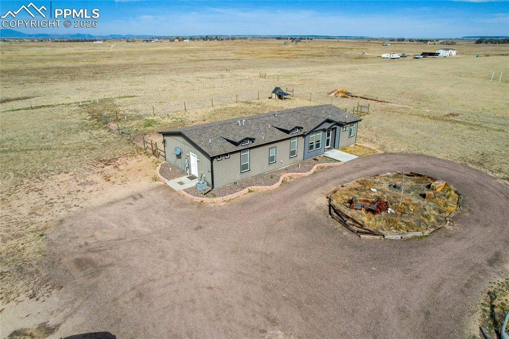 7880 J D Johnson Road Peyton, CO 80831 - Photo 39 of 50 Contemporary ranch-style home featuring gray siding, a dark shingle roof, and multiple windows