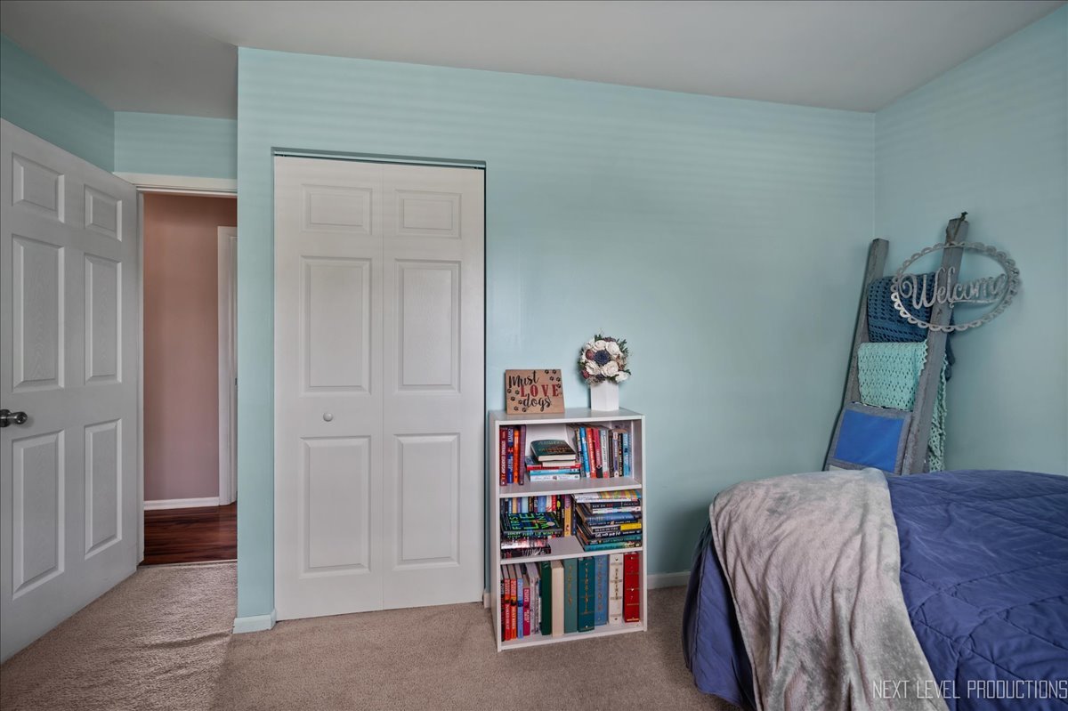 87 Saugatuck Road Montgomery, IL 60538 - Photo 14 of 27 a bed room with a bed and a book shelf