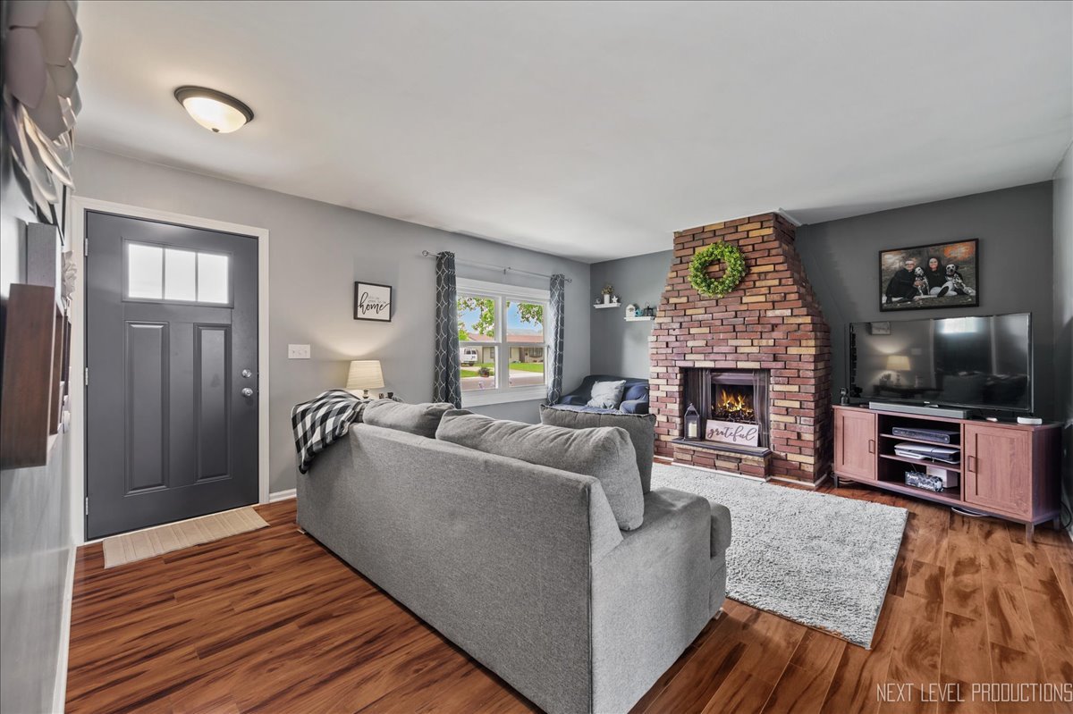 87 Saugatuck Road Montgomery, IL 60538 - Photo 2 of 27 a living room with furniture a flat screen tv and a fireplace
