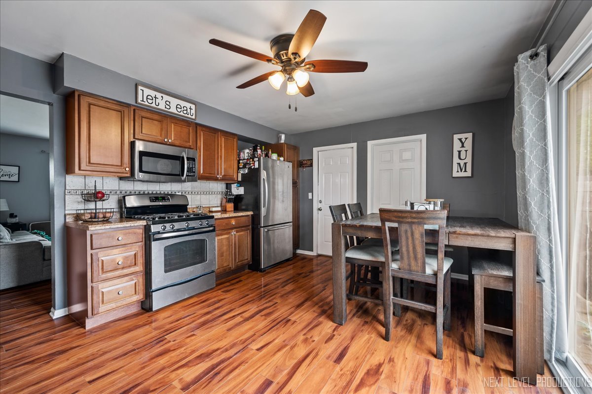 87 Saugatuck Road Montgomery, IL 60538 - Photo 6 of 27 a kitchen with a table chairs microwave and refrigerator