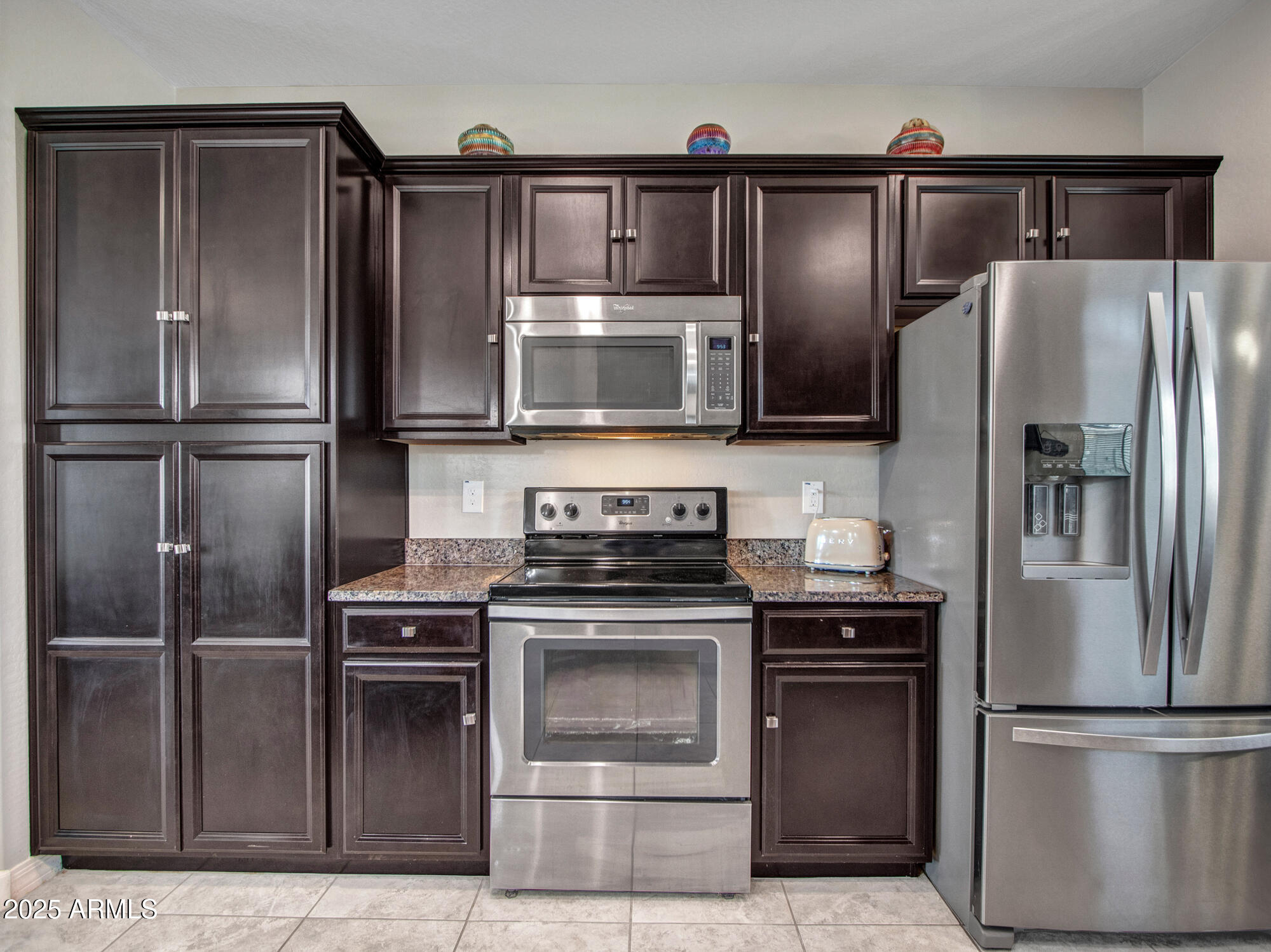 22585 West Moonlight Path Buckeye, AZ 85326 - Photo 12 of 35 a kitchen with granite countertop stainless steel appliances and wooden cabinets