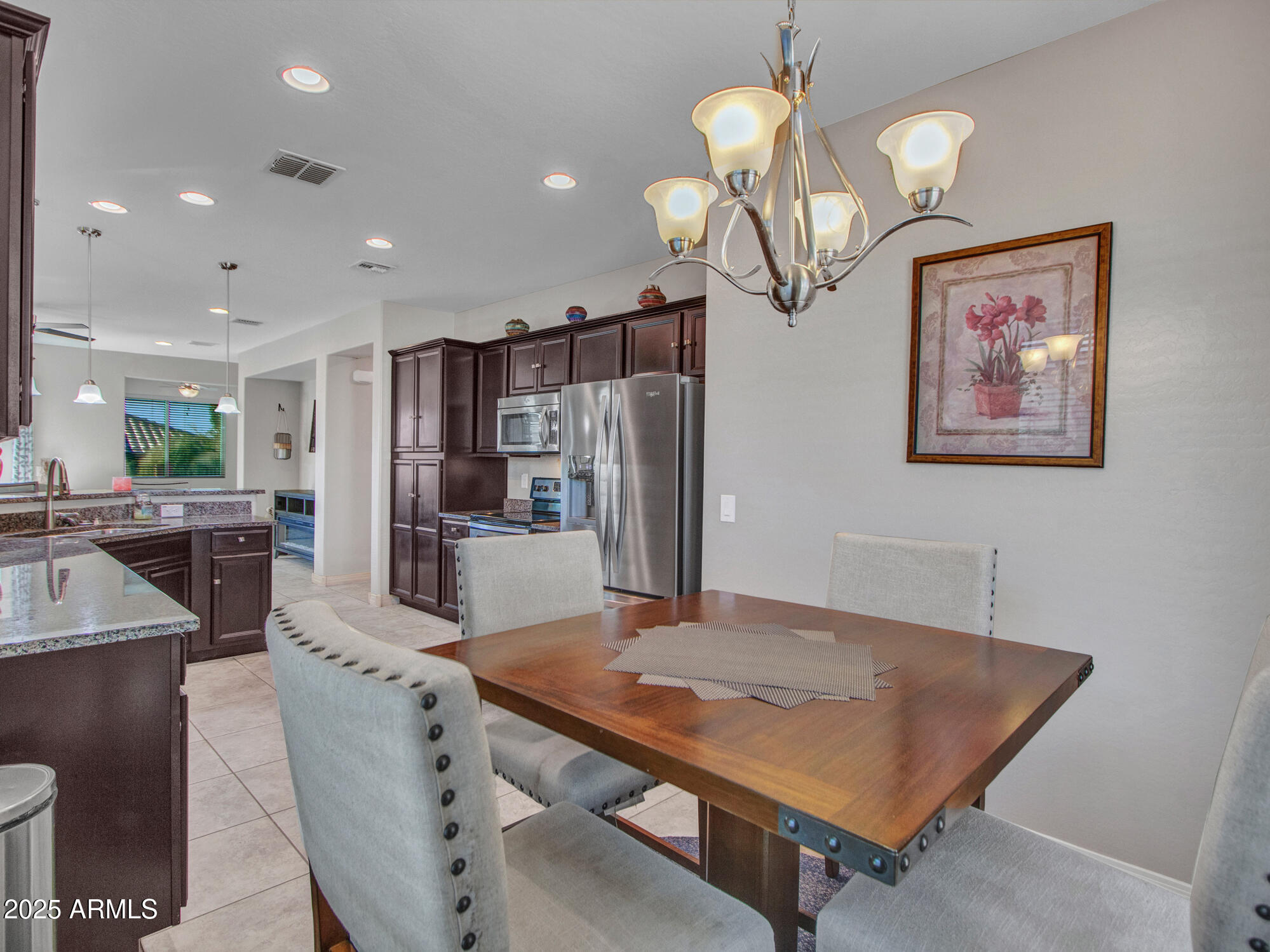 22585 West Moonlight Path Buckeye, AZ 85326 - Photo 16 of 35 a living room with stainless steel appliances furniture a chandelier and a view of kitchen